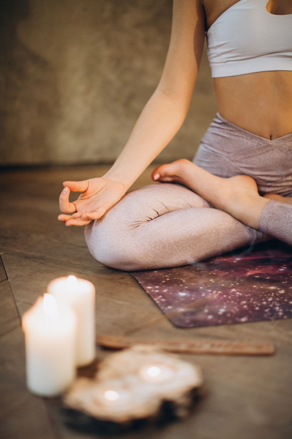 Mains en mudra pendant une méditation à la lueur des bougies